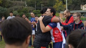 Un par de jugadores se dan un abrazo, ante la vista de los demá asistentes.